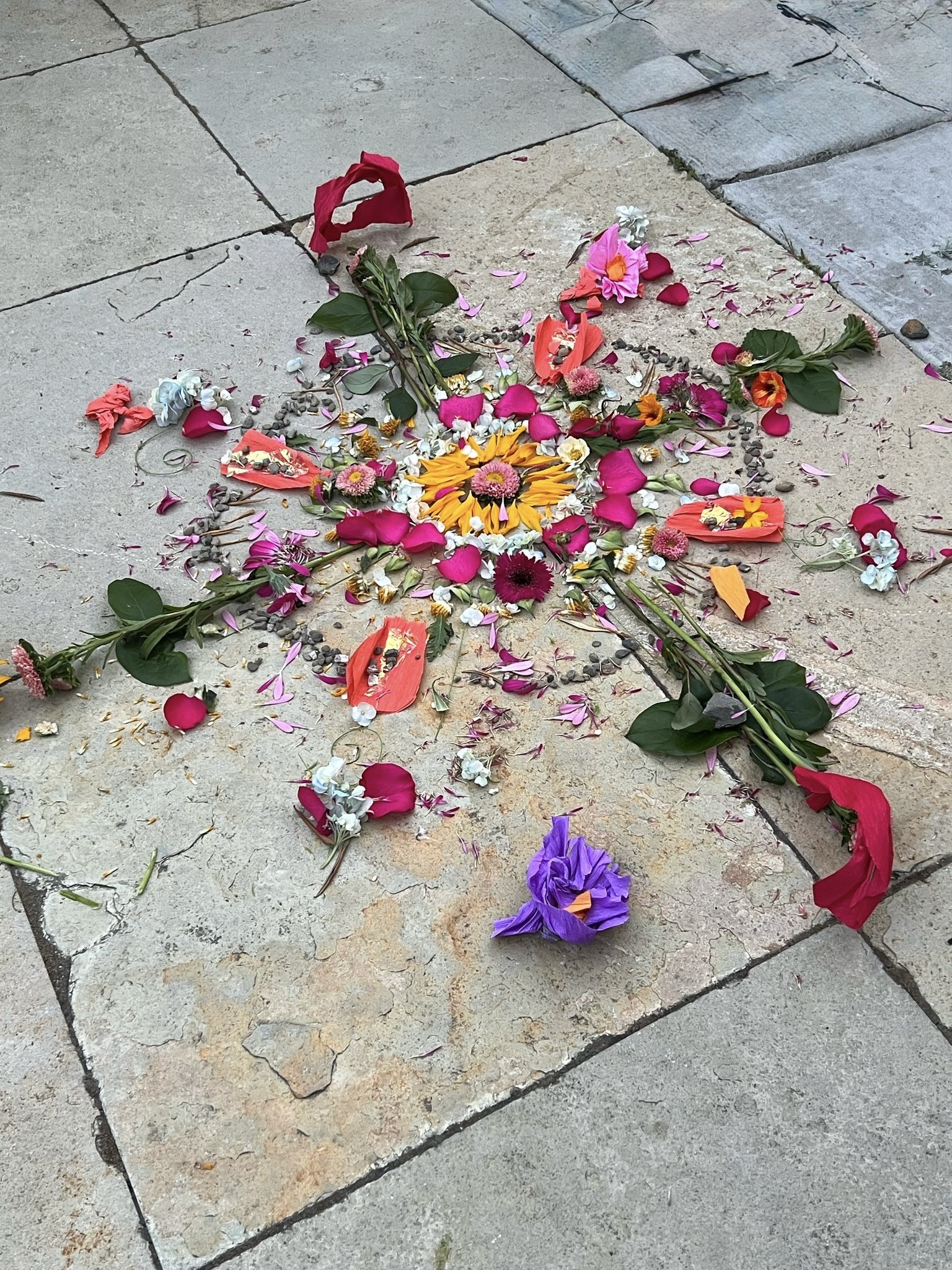 A flower mandala radiating outward on stone pavers — expanding capacity