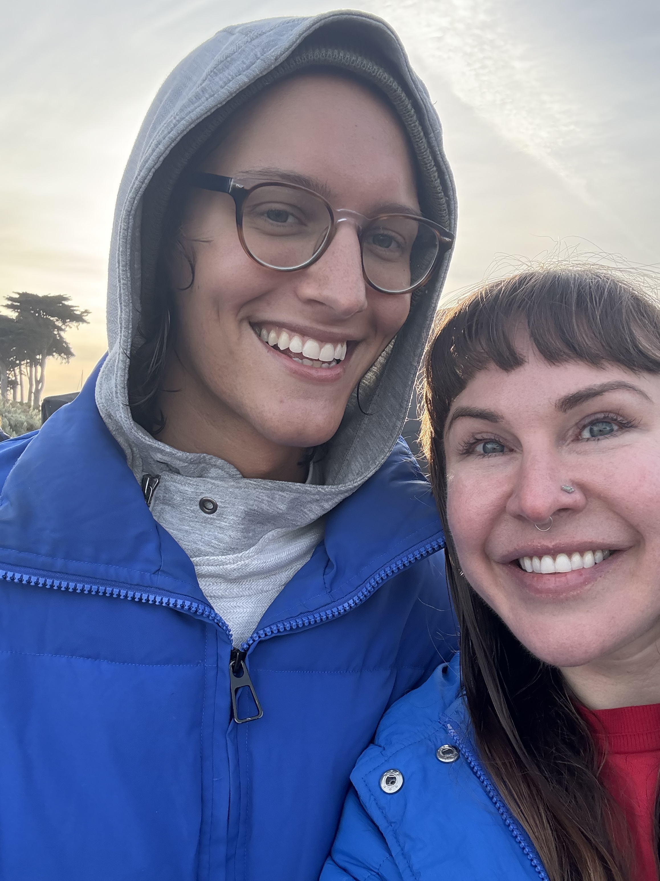 Mars and Andrea smiling at the bay at golden hour