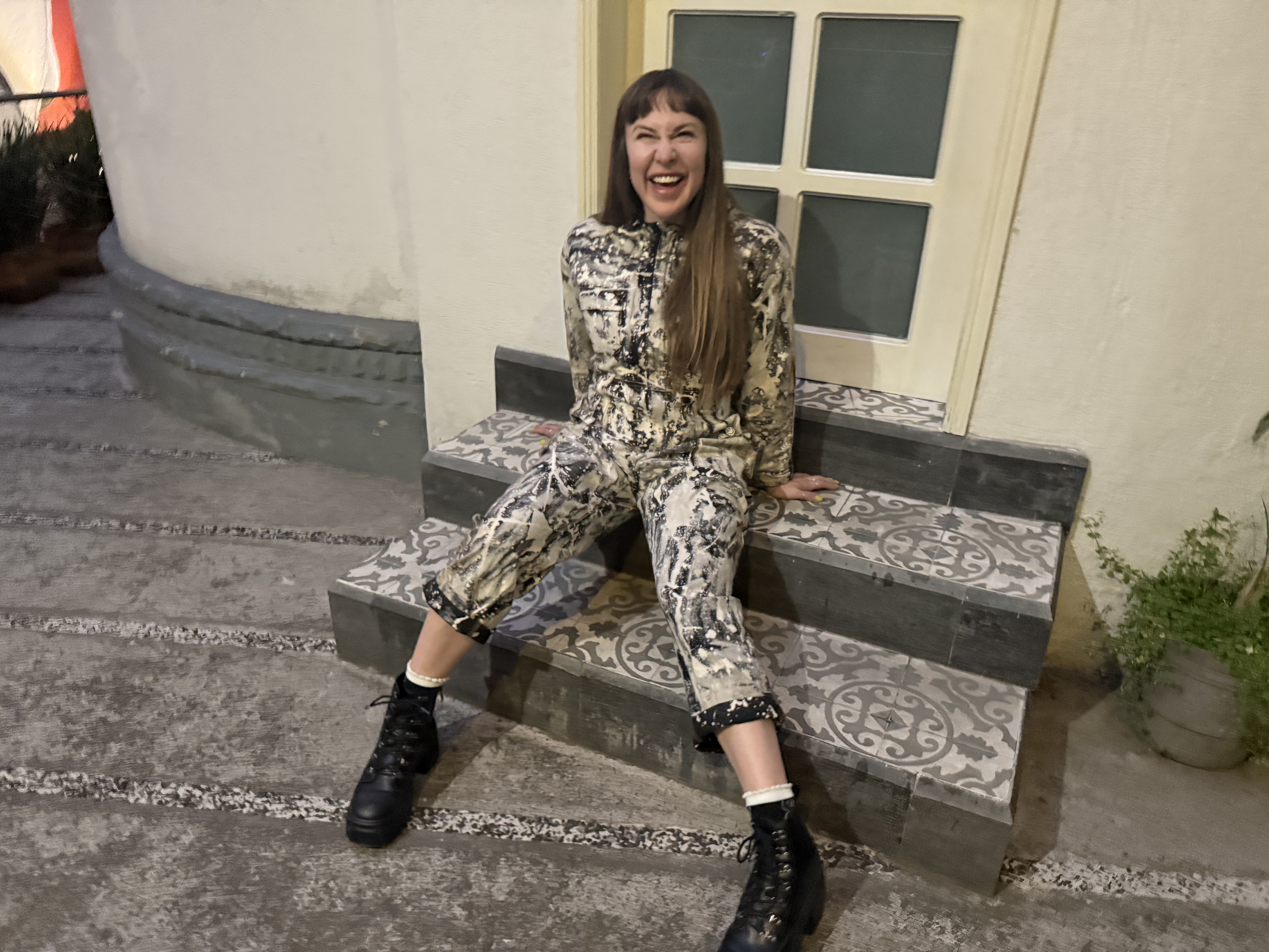 Mars laughing on a tiled outdoor bench at night