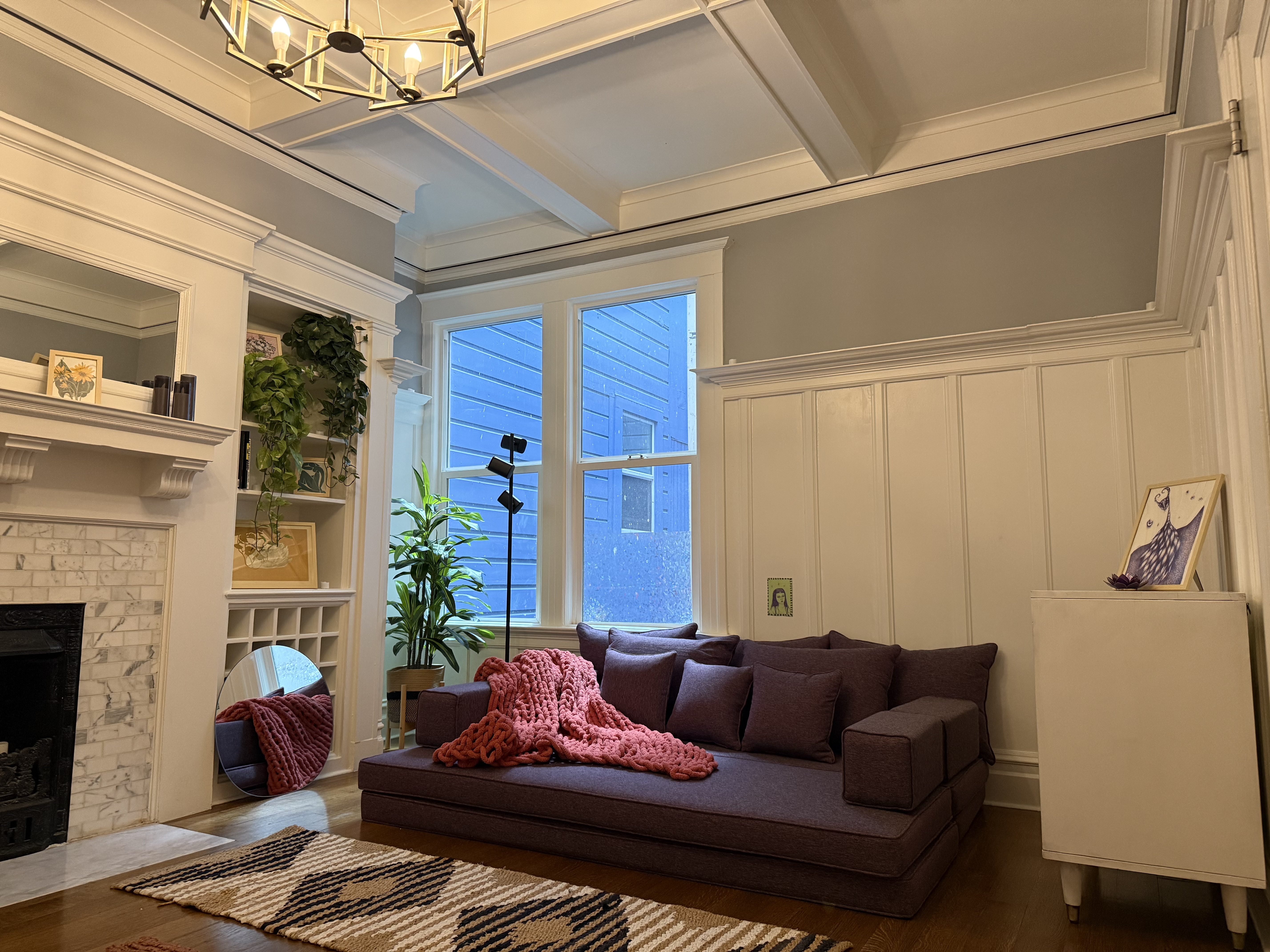 Mars's coaching office — warm Victorian room with fireplace, purple sofa, and plants